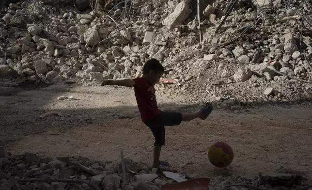 A boy plays with his ball next to debris of a heavily damaged building after an Israeli forces raid in the West Bank city of Jenin, Thursday, May 23, 2024. The Israeli military said Thursday it has completed a two-day operation in the occupied West Bank that the Palestinian Health Ministry says killed 12 Palestinians. Militant groups claimed at least eight of the dead as fighters, one from Hamas and seven from the Al-Aqsa Martyrs Brigade. (AP Photo/Leo Correa)
