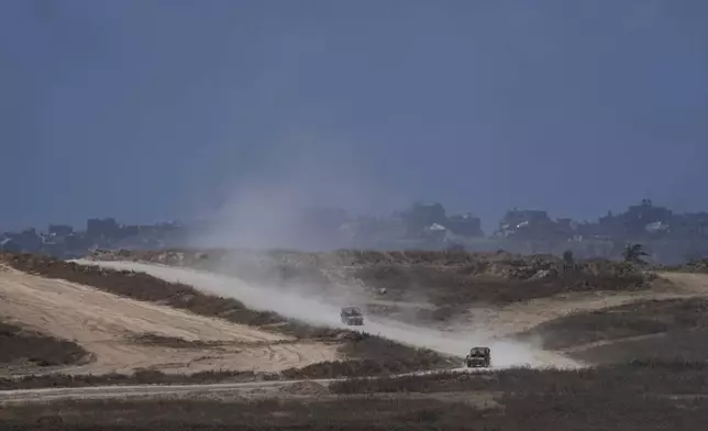 Israeli military vehicles drive in the Gaza Strip as seen from southern Israel, Friday, May 24, 2024. (AP Photo/Tsafrir Abayov)