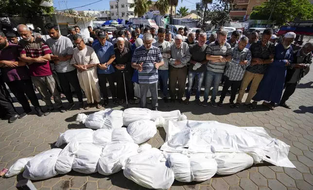 Mourners pray over the bodies of Palestinians, a day after they were killed by Israeli bombardment, at their funeral at Al Aqsa Hospital in Deir al Balah, Friday, May 24, 2024. (AP Photo/Abdel Kareem Hana)