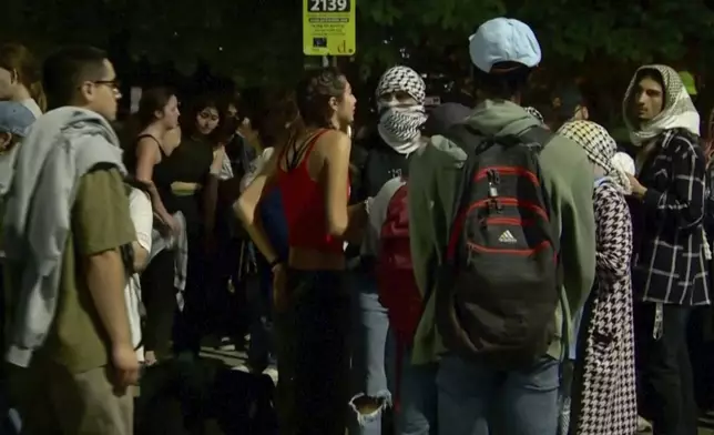 In this image taken from video, protestors against the Israel-Hamas war stand outside near the campus of George Washington University in Washington, Wednesday, May 8, 2024. Tensions have continued to ratchet up in standoffs with protesters on campuses across the U.S. and increasingly, in Europe, nearly three weeks into a movement launched by a protest at Columbia University. (WJLA via AP)