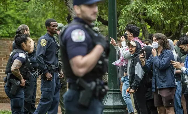 Police and pro-Palestinian demonstrators stand across from one another on the grounds of the University of Virginia, in Charlottesville, Va., where tents are set up, Saturday, May 4, 2024. (Cal Cary/The Daily Progress via AP)