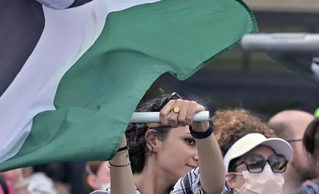 A demonstrator waves a Palestinian flag, Monday, May 6, 2024, in at MIT in Cambridge, Mass. after several hundred demonstrators tore down barricades and joined pro-Palestinian demonstrators that been given a deadline to leave the encampment. (AP Photo/Josh Reynolds)