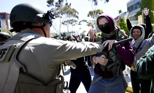 Police officers clash with Pro-Palestinian protesters at UC San Diego, Monday, May 6, 2024, in San Diego. Police cleared a campus Pro-Palestinian encampment in the early morning Monday. (AP Photo/Denis Poroy)