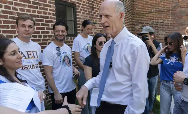 Sen. Rick Scott, R-Fla., shakes hands with supporters of Israel as they demonstrate at George Washington University where pro-Palestinian students protest over the Israel-Hamas war, Thursday, May 2, 2024, in Washington. (AP Photo/Jose Luis Magana)