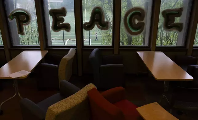 The word "Peace" written by a anti-war protesters is displayed on the windows at Millar Library at Portland State University, Wednesday, May 1, 2024, in Portland, Ore. (AP Photo/Jenny Kane)
