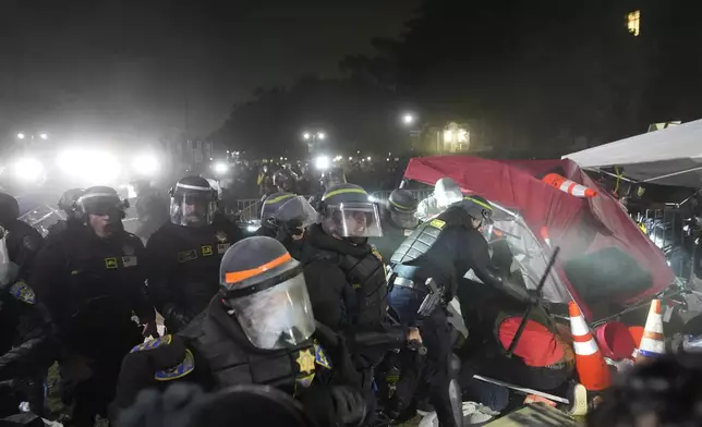 Police break through a barrier set up by pro-Palestinian demonstrators on the UCLA campus Thursday, May 2, 2024, in Los Angeles. (AP Photo/Jae C. Hong)