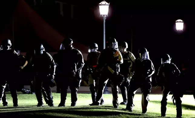 Officers from several area law enforcement agencies form a line and advance on an encampment of pro-Palestinian demonstrators on the University of Arizona campus, Friday, May 10, 2024, Tucson, Az. (Kelly Presnell/Arizona Daily Star via AP)