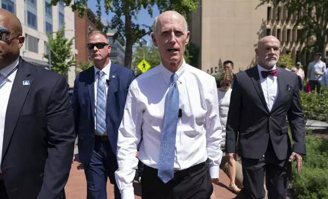 Sen. Rick Scott, R-Fla., center, leaves a demonstration at George Washington University where pro-Palestinian students and supporters of Israel protest over the Israel-Hamas war, Thursday, May 2, 2024, in Washington. (AP Photo/Jose Luis Magana)