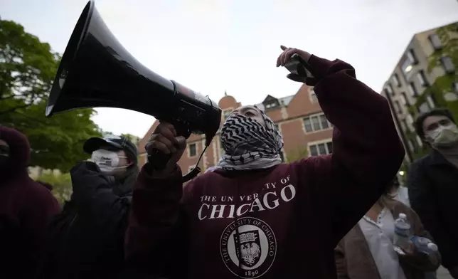A pro-Palestinian protester leads chants at the university's police as they are kept from the university's quad while the student encampment is dismantled at the University of Chicago, on Tuesday, May 7, 2024, in Chicago. (AP Photo/Charles Rex Arbogast)