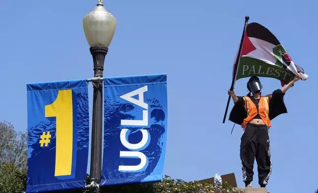 Demonstrators wave flags on the UCLA campus, after nighttime clashes between Pro-Israel and Pro-Palestinian groups, Wednesday, May 1, 2024, in Los Angeles. (AP Photo/Jae C. Hong)