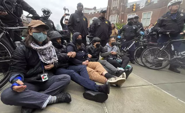 Protesters lock arms on Penn campus as police clear the encampment showing support for Palestinians in Gaza, at University of Pennsylvania, in Philadelphia, Friday, May 10, 2024. (Jessica Griffin/The Philadelphia Inquirer via AP)
