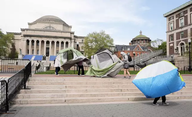 Student protesters move tents from the center of campus to entrance of Hamilton Hall on the campus of Columbia University, Tuesday, April 30, 2024, in New York. Early Tuesday, dozens of protesters took over Hamilton Hall, locking arms and carrying furniture and metal barricades to the building. Columbia responded by restricting access to campus. (AP Photo/Mary Altaffer, Pool)
