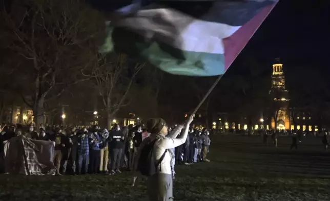 A pro-Palestinian protester waves a Palestinian flag on the campus of Dartmouth College on Wednesday, May 1, 2024 in Hanover, N.H. (David Adkins via AP)