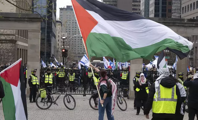 A pro-Palestinian supporter waves a flag as pro-Palestinians and pro-Israel supporters hold opposing demonstrations at the McGill University campus, in Montreal, Thursday, May 2, 2024. (Ryan Remiorz/The Canadian Press via AP)