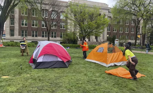 People hold blankets and take down the final tents standing at an encampment in support of Palestinians at the University of Minnesota in Minneapolis, Minn., on May 2, 2024. Earlier in the day, University of Minnesota officials announced an agreement with protesters to end the encampment on the Minneapolis campus. (AP Photo/Trisha Ahmed)