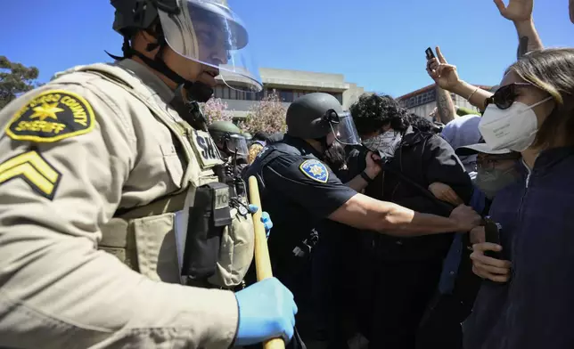 Police officers clash with Pro-Palestinian protesters at UC San Diego Monday, May 6, 2024, in San Diego. Police cleared a campus encampment in the early morning Monday. (AP Photo/Denis Poroy)