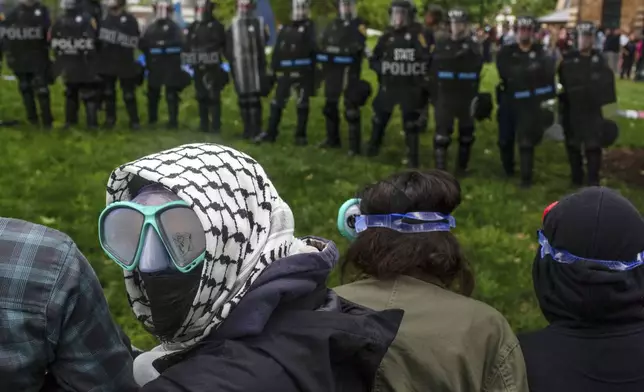 A pro-Palestinian demonstrator wears goggles and a mask as police with riot shields and protesters clash on the grounds of the University of Virginia, in Charlottesville, Va., where tents are set up, Saturday, May 4, 2024. (Cal Cary/The Daily Progress via AP)