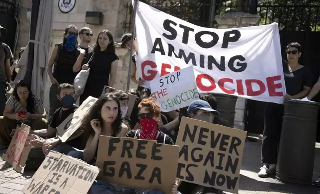 Israeli and American activists block the entrance to the U.S. Consulate building that houses the Palestinian Affairs Unit, calling for the United States to stop providing arms to Israel for the war in the Gaza Strip, in Jerusalem, Friday, May 24, 2024. (AP Photo/Maya Alleruzzo)