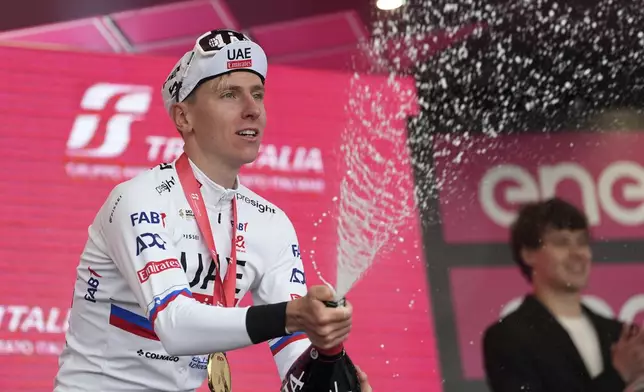 Tadej Pogačar celebrates on podium after winning stage 2 of the Giro d'Italia from San Francesco al Campo to Santuario di Oropa, Italy, Sunday, May 5, 2024. (Massimo Paolone/LaPresse via AP)