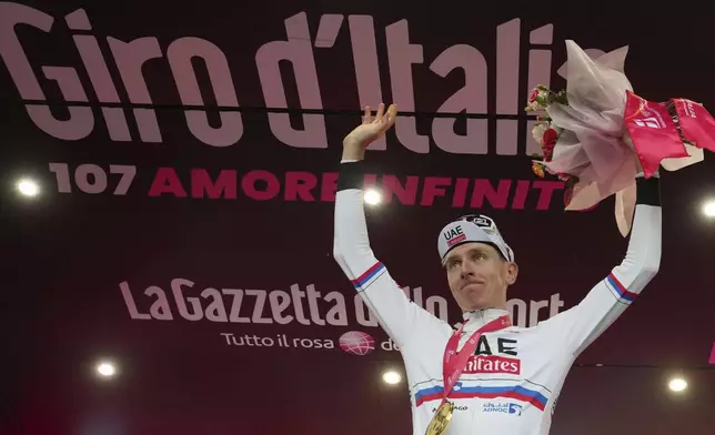 Tadej Pogačar celebrates on podium after winning stage 2 of the Giro d'Italia from San Francesco al Campo to Santuario di Oropa, Italy, Sunday, May 5, 2024. (Gian Mattia D'Alberto/LaPresse via AP)