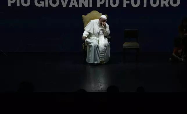 Pope Francis gestures as he sits during an annual gathering of pro-family organisations at the Auditorium della Conciliazione, in Rome, Friday, May 10, 2024. The writing in the back reads "more young people more future." (AP Photo/Alessandra Tarantino)