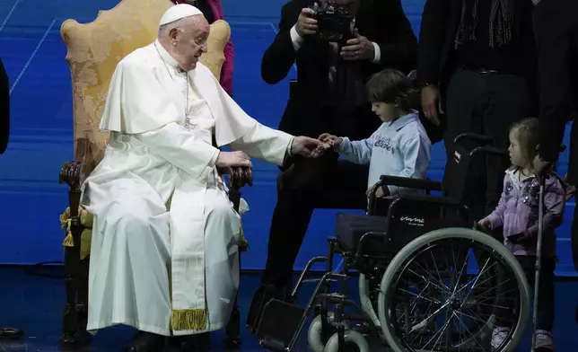 Pope Francis presents sweet treats to children during an annual gathering of pro-family organisations at the Auditorium della Conciliazione, in Rome, Friday, May 10, 2024. (AP Photo/Alessandra Tarantino)