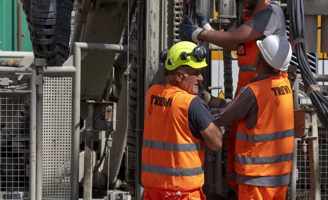 Workers inject reactive chemicals to consolidate the construction site of the new 25.5-kilometer Metro C subway main hub in Piazza Venezia in central Rome, Thursday, May 23, 2024. During a tour Thursday of the construction site at Piazza Venezia, chief engineer Andrea Sciotti said works on the nearly 3 billion euro project, considered one of the most complicated in the world, were running at pace to be completed by 2034. In the background the Unknown Soldier monument. (AP Photo/Domenico Stinellis)