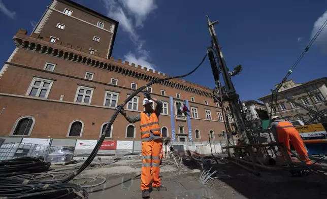 Workers inject reactive chemicals to consolidate the construction site of the new 25.5-kilometer Metro C subway main hub in Piazza Venezia in central Rome, Thursday, May 23, 2024. During a tour Thursday of the construction site at Piazza Venezia, chief engineer Andrea Sciotti said works on the nearly 3 billion euro project, considered one of the most complicated in the world, were running at pace to be completed by 2034. In the background the Unknown Soldier monument. (AP Photo/Domenico Stinellis)