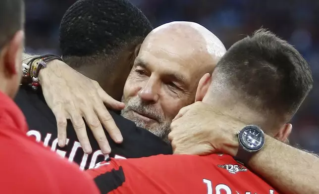 AC Milan manager Stefano Pioli, center, hugs players after the Serie A soccer match between Milan and Salernitana at the Giuseppe Meazza Stadium in Milan, Italy, Saturday, May 25, 2024. (Alberto Mariani/LaPresse via AP)