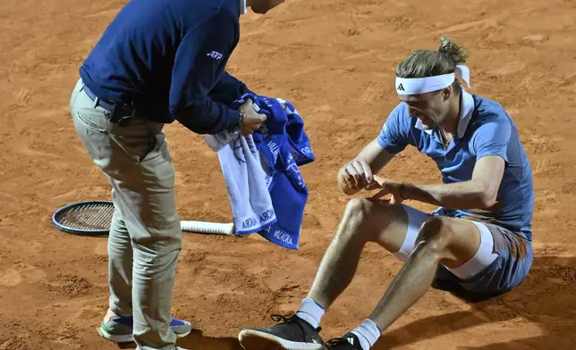 Germany's Alexander Zverev is helped after falling during his match against Taylor Fritz of the United States at the Italian Open tennis tournament at Rome's Foro Italico, Wednesday, May 15, 2024. (AP Photo/Antonietta Baldassarre)