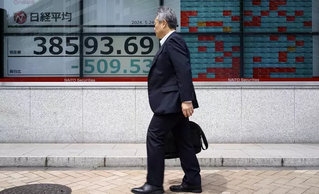 A person walks in front of an electronic stock board showing Japan's Nikkei 225 index at a securities firm Friday, May 24, 2024, in Tokyo. (AP Photo/Eugene Hoshiko)