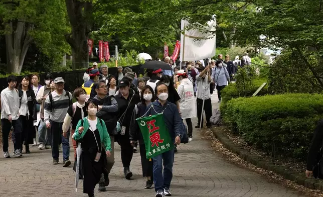 People walk towards the site of a May Day rally in Tokyo, Wednesday, May 1, 2024. (AP Photo/Hiro Komae)