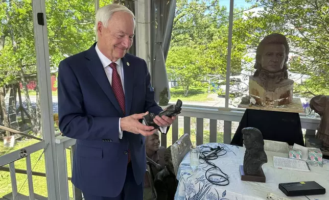 Former Arkansas Gov. Asa Hutchinson holds a small-scale statue of Johnny Cash, on April 23, 2024, in Little Rock, Ark. Artist Kevin Kresse's full sculpture of Cash will be unveiled at the U.S. Capitol as part of the Statuary Hall collection, later this year. (AP Photo/Andrew DeMillo)