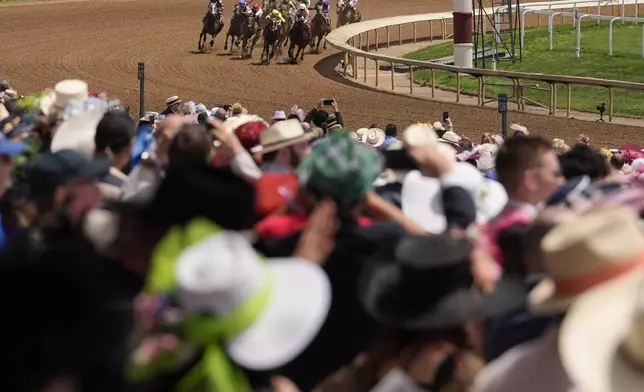 Race fans watch a race at Churchill Downs before the 150th running of the Kentucky Derby horse race Saturday, May 4, 2024, in Louisville, Ky. (AP Photo/Brynn Anderson)