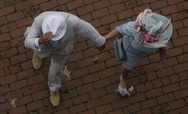 Race fans arrives at Churchill Downs before the 150th running of the Kentucky Derby horse race Saturday, May 4, 2024, in Louisville, Ky. (AP Photo/Charlie Riedel)