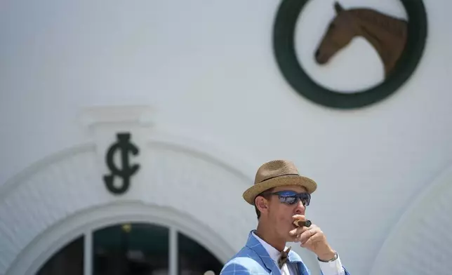 A race fan walks though the grounds of Churchill Downs before the 150th running of the Kentucky Derby horse race Saturday, May 4, 2024, in Louisville, Ky. (AP Photo/Charlie Riedel)
