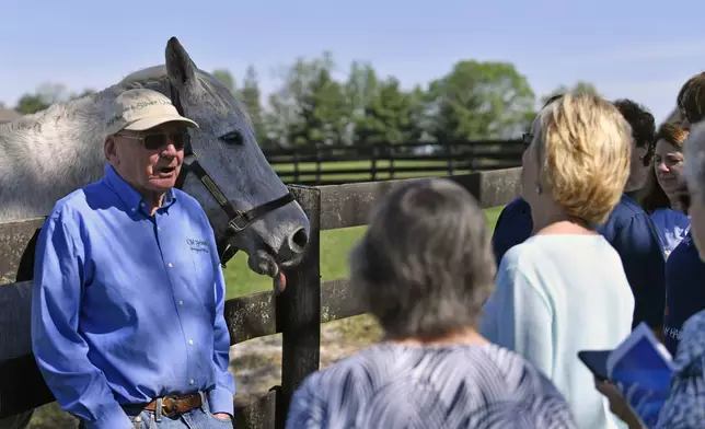 Michael Blowen, left, founder and retired president of Old Friends Farm, speaks with a group of tourists as they visit the 1997 Kentucky Derby winner Silver Charm, during a tour of Old Friends Farm in Georgetown, Ky., Thursday, April 18, 2024. At the age of 30, Silver Charm, the oldest living Derby winner lives in retirement at the farm, dedicated to retired thoroughbred race horses. (AP Photo/Timothy D. Easley)