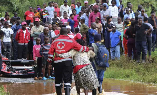 FILE - A woman is rescued from her flooded house by Red Cross workers in Githurai area of Nairobi, Kenya, April 24, 2024. (AP Photo/Edaward Odero, File)
