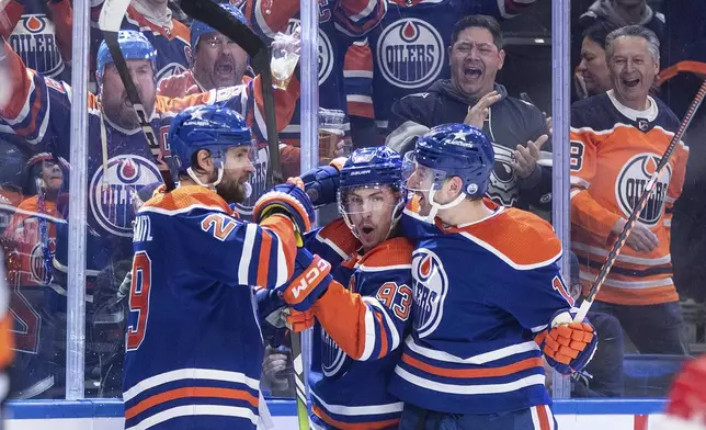 Edmonton Oilers' Leon Draisaitl (29), Ryan Nugent-Hopkins (93) and Zach Hyman (18) celebrate a goal against the Los Angeles Kings during the second period in Game 5 of an NHL hockey Stanley Cup first-round playoff series, on Wednesday May 1, 2024, in Edmonton, Alberta. (Jason Franson/The Canadian Press via AP)
