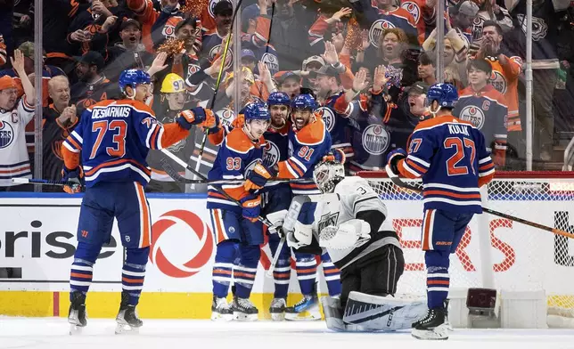 Los Angeles Kings goalie David Rittich (31) looks on as Edmonton Oilers' Vincent Desharnais (73), Ryan Nugent-Hopkins (93), Leon Draisaitl (29), Evander Kane (91) and Brett Kulak (27) celebrate a goal during the first period in Game 5 of an NHL hockey Stanley Cup first-round playoff series, on Wednesday May 1, 2024 in Edmonton, Alberta. (Jason Franson/The Canadian Press via AP)