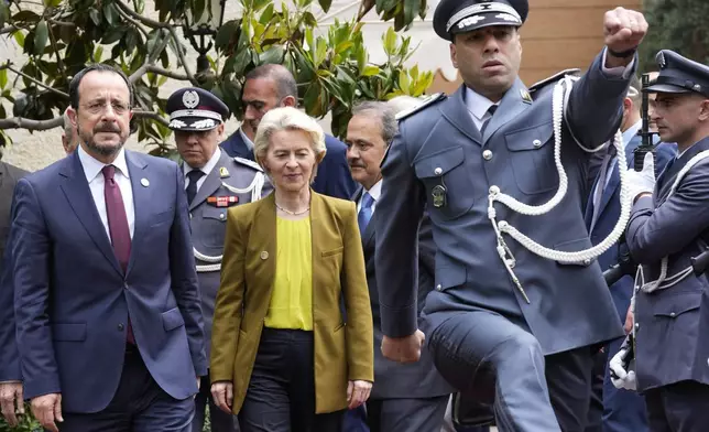 Cyprus' President Nikos Christodoulides, left, and President of the European Commission Ursula von der Leyen, center, review an honor guard upon their arrival to meet with the Lebanese Speaker Nabih Berri, in Beirut, Thursday, May 2, 2024. (AP Photo/Hussein Malla)
