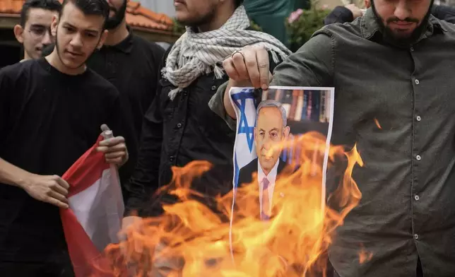 Students from the Lebanese American University (LAU) burn a picture of Israeli Prime Minister Benjamin Netanyahu during a protest inside their university campus to demand a ceasefire and show support for Palestinians in the Gaza Strip, in Beirut, Lebanon, Tuesday, April 30, 2024. Scores of students held pro-Palestinian protests at some of the largest universities in Beirut Tuesday expressing anger over the rising deaths during the Israel-Hamas war. (AP Photo/Hassan Ammar)