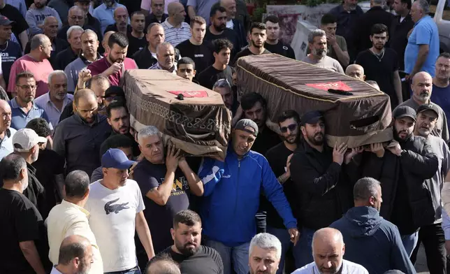 Mourners carry the coffins of two victims who were among four civilians from the same family that killed on Sunday by Israeli strikes on the southern town of Mays al-Jabal, during their funeral procession, in Beirut, Monday, May 6, 2024. Hezbollah militants and Israeli forces have been exchanging fire in south Lebanon since a day after the Israel-Hamas war began on Oct. 7. (AP Photo/Hussein Malla)