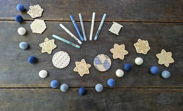 This image shows a display from the Snowflake Kit, one of Woodsy Craft Co’s kits which include felt balls, markers, thread and an array of themed lasercut wood decorations. (Kim Cook via AP)