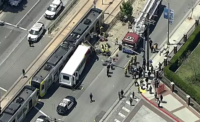 In this aerial still image provided by KABC-TV, firefighters respond to the scene of an accident where a shuttle bus collided with a Metro light rail train on Tuesday, April 30, 2024, in Los Angeles. (KABC via AP)