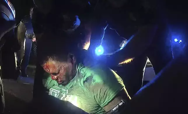 FILE - This image from video from Louisiana state police state trooper Dakota DeMoss' body-worn camera, shows troopers holding up Ronald Greene before paramedics arrived on May 10, 2019, outside of Monroe, La. The video obtained by The Associated Press shows Louisiana state troopers stunning, punching and dragging the Black man as he apologizes for leading them on a high-speed chase. (Louisiana State Police via AP)