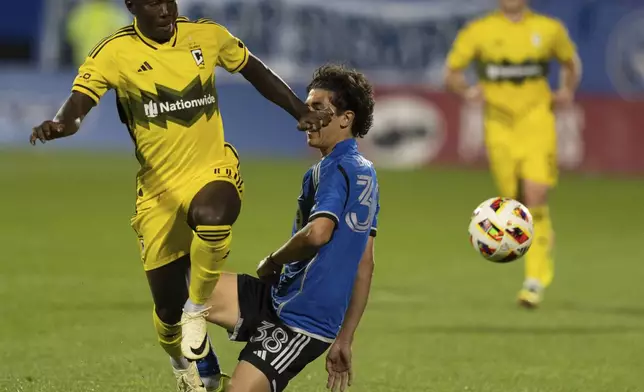 Columbus Crew midfielder Marino Hinestroza (11) drives the ball past CF Montreal's Alessandro Biello (38) during the second half of an MLS soccer game, Wednesday, May 15, 2024 in Montreal.(Christinne Muschi/The Canadian Press via AP)