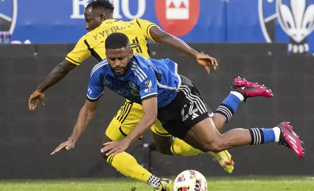 CF Montreal defender Ruan (22) is tripped up as he battles against Columbus Crew midfielder Yaw Yeboah (14) during the first half of an MLS soccer game, Wednesday, May 15, 2024 in Montreal.(Christinne Muschi/The Canadian Press via AP)