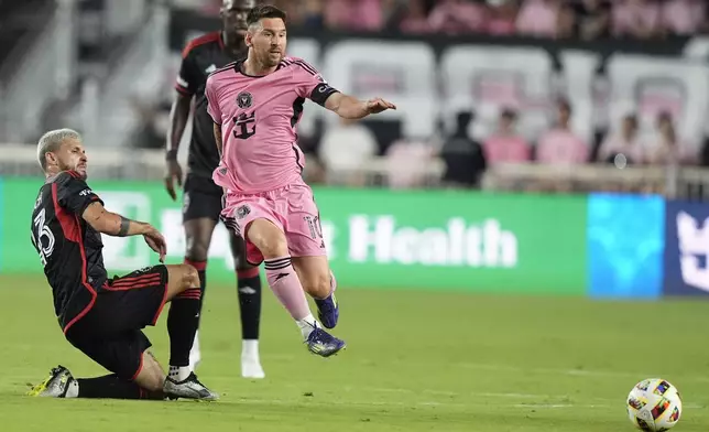 Inter Miami forward Lionel Messi, right, kicks the ball during the first half of an MLS soccer match against D.C. United, Saturday, May 18, 2024, in Fort Lauderdale, Fla. At left is D.C. United midfielder Mateusz Klich. (AP Photo/Lynne Sladky)