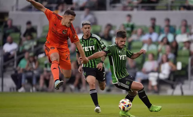 Houston Dynamo defender Erik Sviatchenko (28) and Austin FC forward Diego Rubio, right, chase a pass during the first half of an MLS soccer match, Wednesday, May 15, 2024, in Austin, Texas. (AP Photo/Eric Gay)